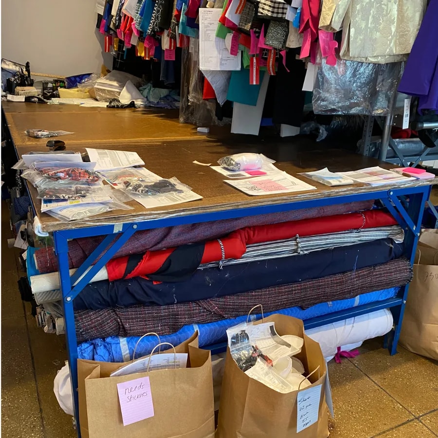 A garment production worktable and fabric racks